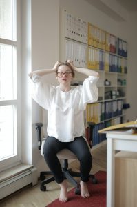 Woman sitting on stool pulling at her hair to signify stress about finding your passion or growing it