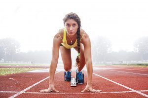 Focused woman preparing to run track race