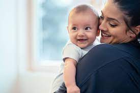 Mom holding smiling baby