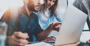 Man and woman sitting looking at computer screen