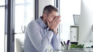 Man sitting at desk in frustration