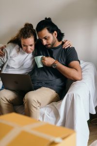 Couple sitting on the couch to signify the importance of talking about carrying the mental load