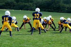 Young children playing football to celebrate helping kids find fun in sports