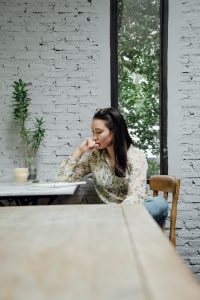 Woman sitting alone in the kitchen to demonstrate coping with regret