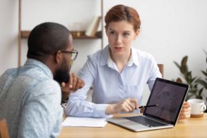 Photo of man and woman sitting at table together to represent does coaching work