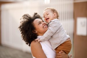 Image of mom holding baby and laughing to demonstrate does coaching work