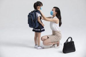 Mom putting a mask on her child