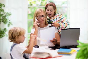Image of mom working from home with two children nearby