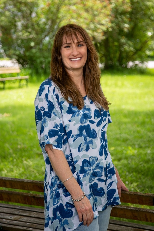 Image of Dr Stephen, online life coach for moms, in a park wearing a blue shirt looking into the camera 