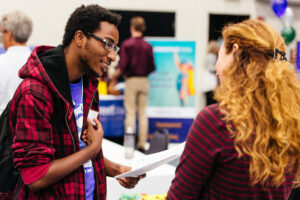 Young man at a career fair speaking with a career coach