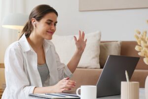 Woman waving to computer screen