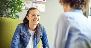 Young woman sitting on a sofa talking to a career coach