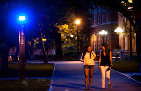 Two young women walking alone on college campus at night