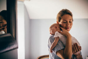 New mom holding baby and smiling