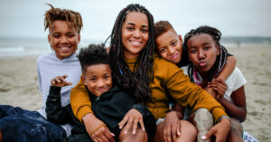 Mom smiling at camera surrounded by four children