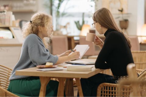 Woman sitting at a table talking to a life coach