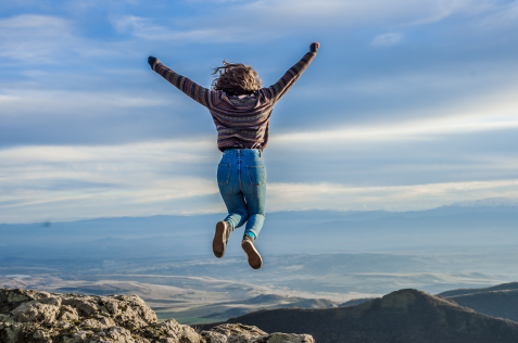 Image of a woman jumping to celebrate accomplishing her goals