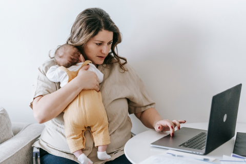Woman holding a small baby while she works
