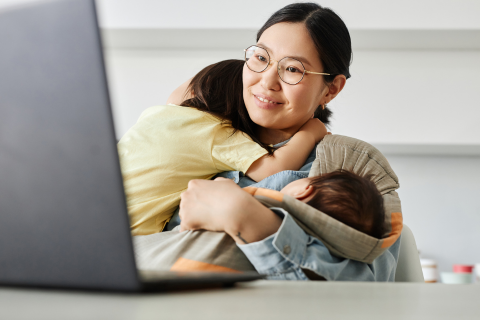 Working mom holding a baby and a toddler