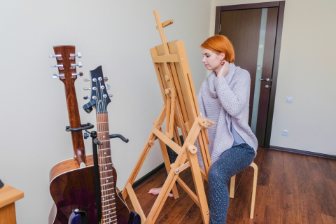 Woman painting in a room with musical instruments to represent finding your passion or growing it