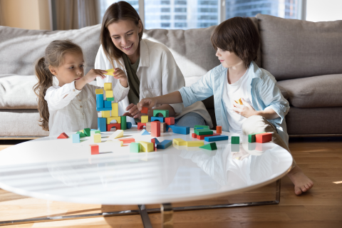 Mom sitting with children playing with blocks to signify giftedness