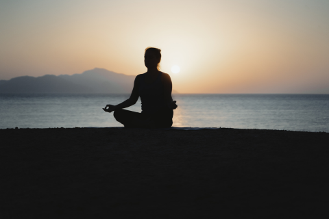 Image of person meditating on a beach